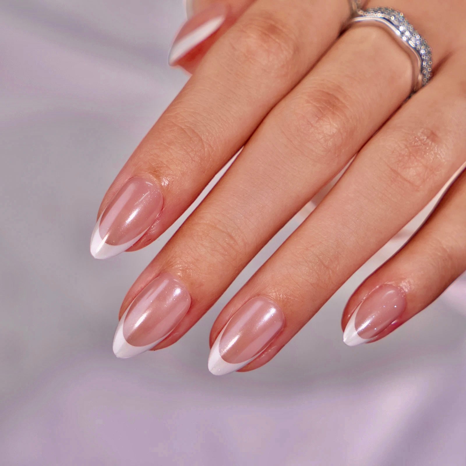 Hand showing press on nails design on white French tip with chrome overlay 