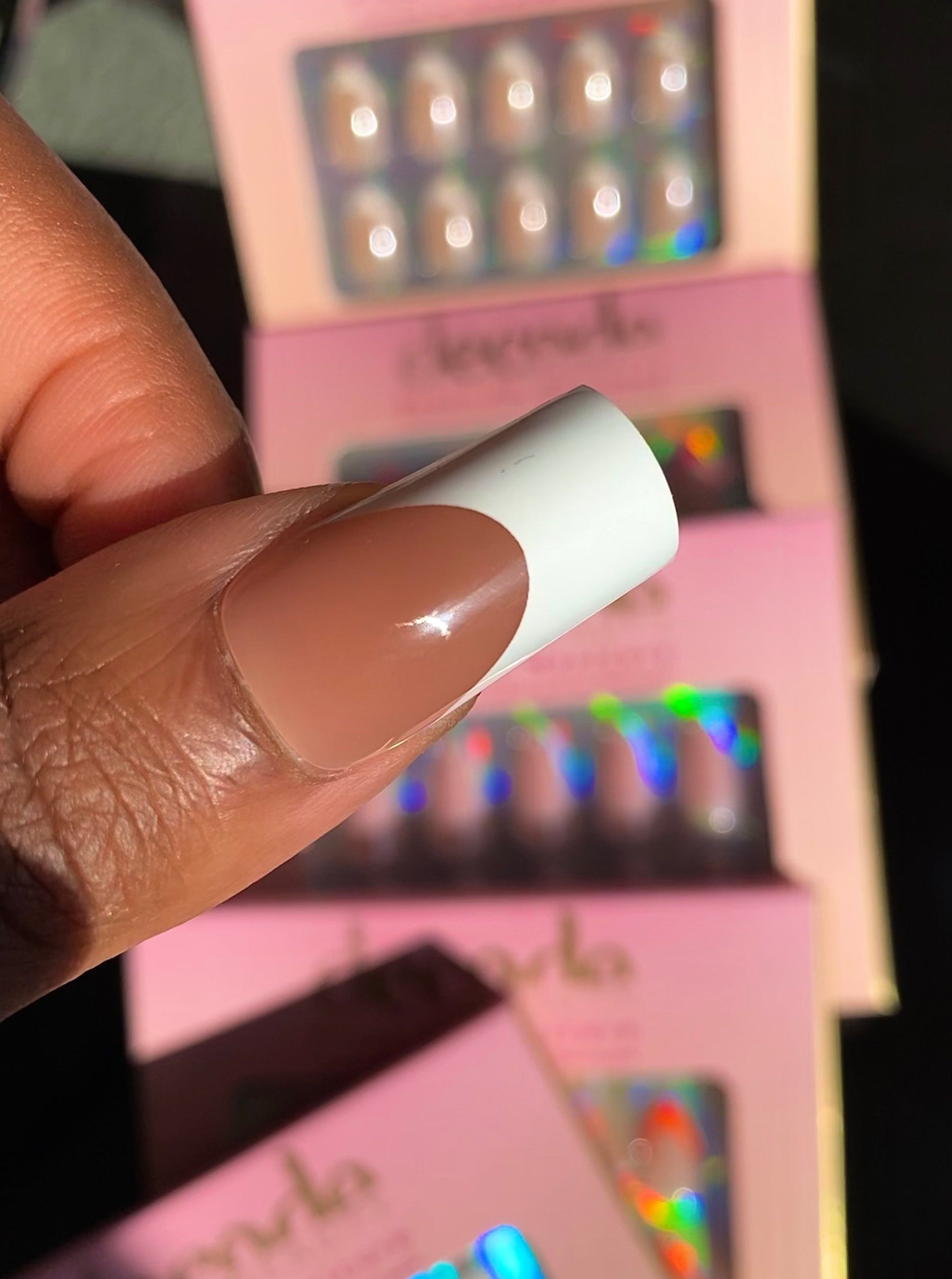 Hand wearing decode beauty white French tip press on nails in long square shape 