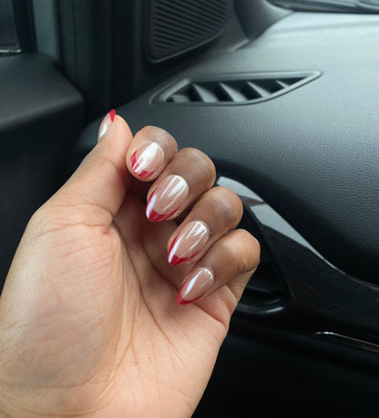 Hand wearing decode beauty red almond French tip chrome nails design 