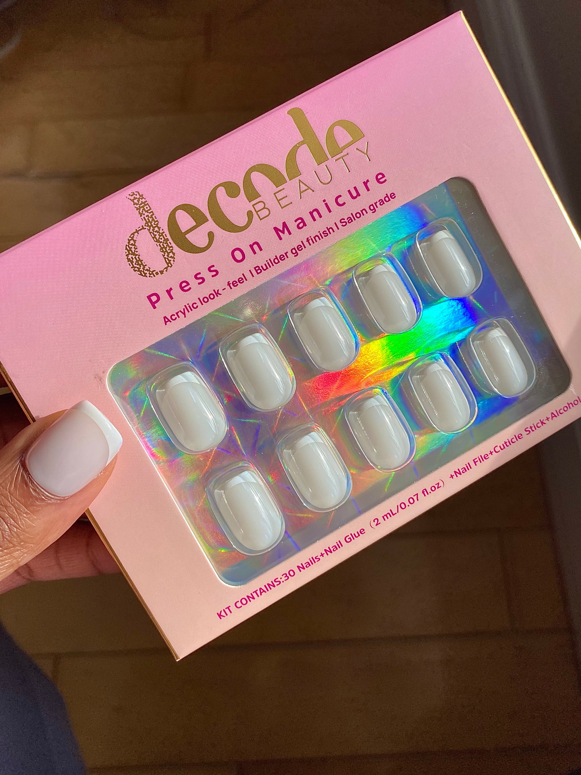 Hand showing decode beauty Short white French tip press on nails 